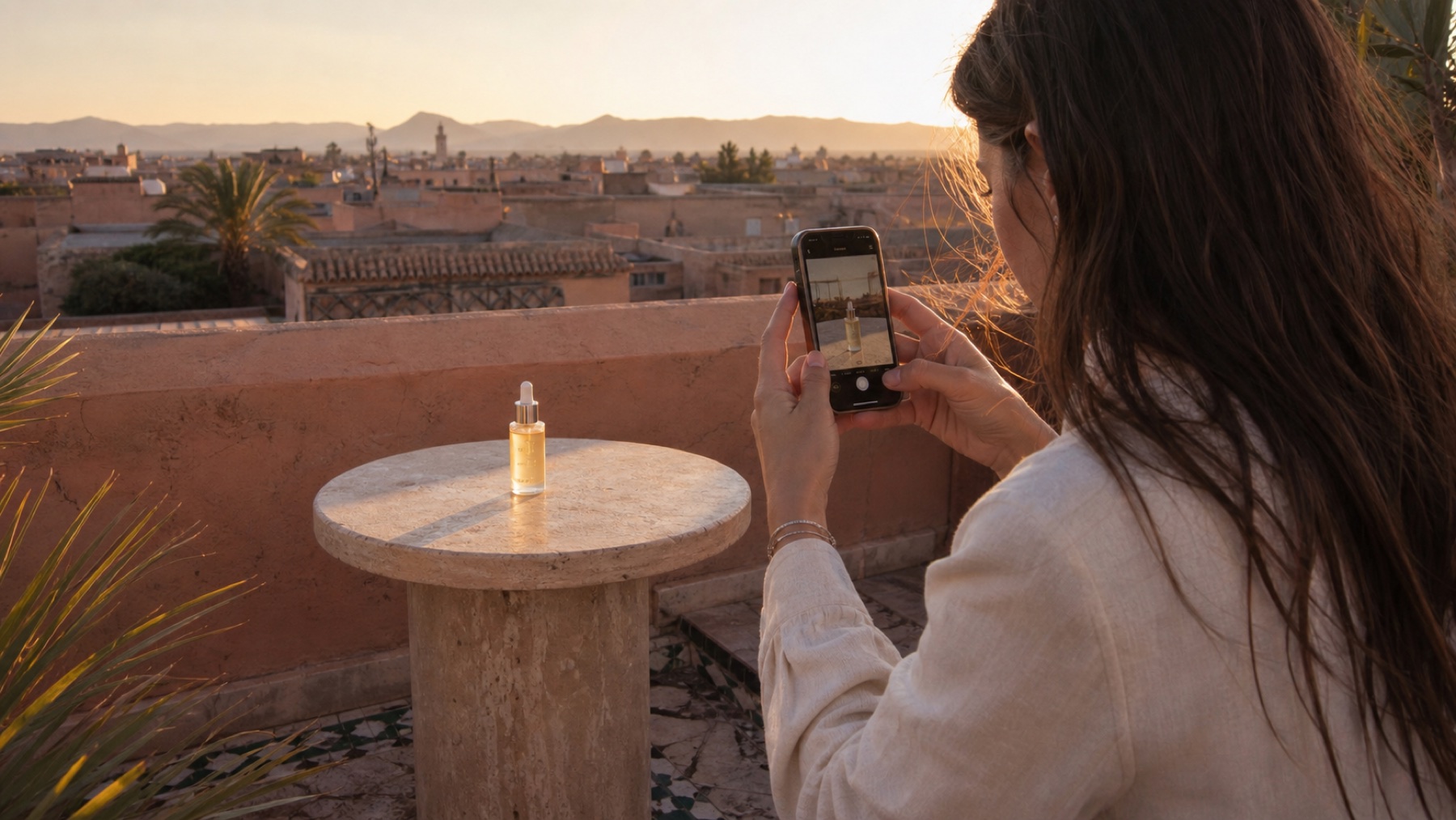 A creator photographing an unbranded skincare product on a Marrakech rooftop